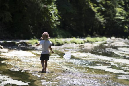 Téléchargez les photos : Bonne petite fille jouant dans la rivière - en image libre de droit