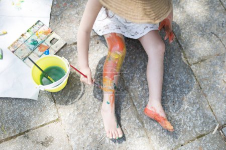 Little girl playing with paint