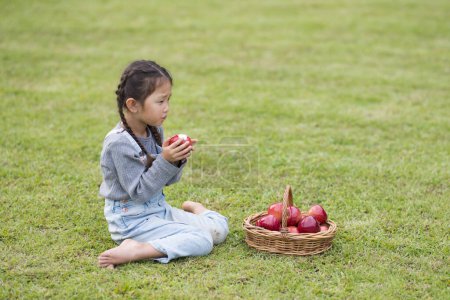 Téléchargez les photos : Petite fille mangeant une pomme - en image libre de droit