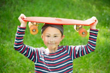 Photo for Young girl playing with skateboard in the park - Royalty Free Image