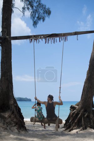 Foto de Padre e hija montando un columpio en la playa - Imagen libre de derechos