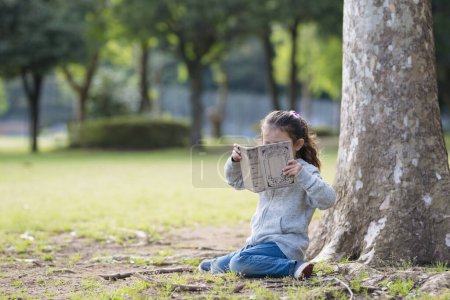 Téléchargez les photos : Petite fille lisant un livre - en image libre de droit