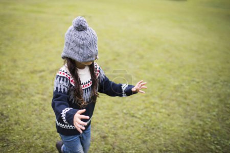 Téléchargez les photos : Petite fille qui a les yeux bandés avec un bonnet en tricot - en image libre de droit