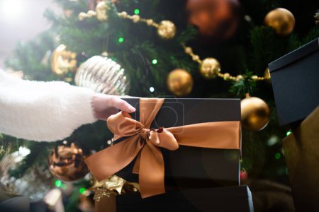 Photo for Female hand holding a Christmas present - Royalty Free Image