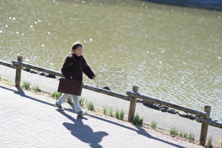 Foto de Niña caminando con una bolsa - Imagen libre de derechos
