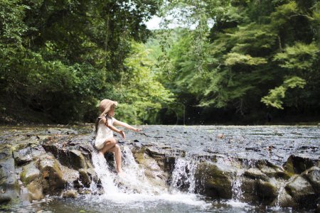 Téléchargez les photos : Petite fille jouant dans le ruisseau de montagne - en image libre de droit