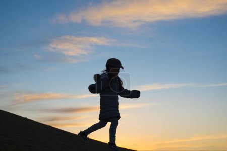 Téléchargez les photos : Silhouette de petite fille marchant en descente - en image libre de droit