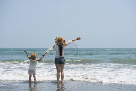 Téléchargez les photos : Mère et fille jouant sur la plage - en image libre de droit