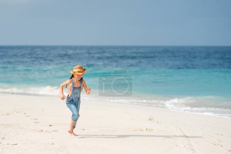 Téléchargez les photos : Petite fille sur la plage de sable fin - en image libre de droit