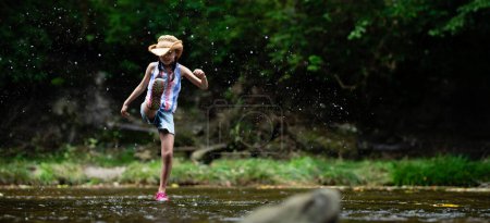 Téléchargez les photos : Un enfant qui fait remonter l'eau dans un ruisseau de montagne - en image libre de droit