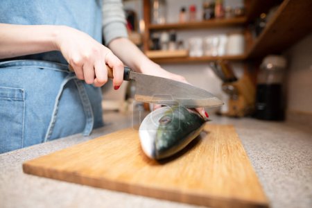 Photo for Female cooking raw fish in the kitchen - Royalty Free Image