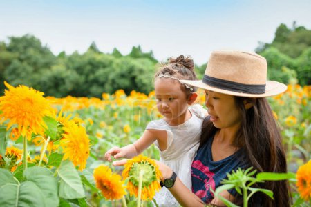 Photo for Mother and daughter playing in a flower field - Royalty Free Image