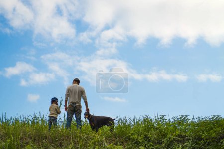 Téléchargez les photos : Père, fille et chien jouant dans la prairie - en image libre de droit
