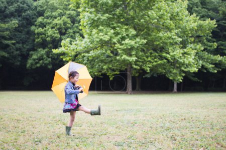 Téléchargez les photos : Petite fille avec parapluie dans le parc. - en image libre de droit