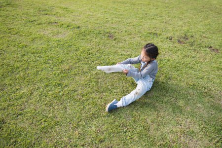 Téléchargez les photos : Mignonne asiatique petite fille sur vert herbe - en image libre de droit