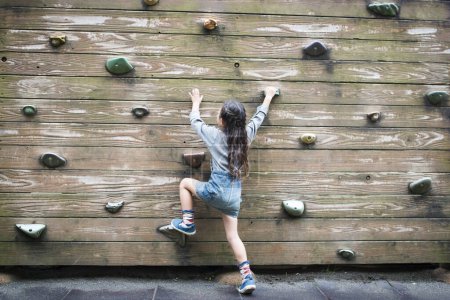 Photo for Little girl climbing the wall - Royalty Free Image