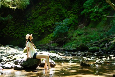 Eine Frau entspannt sich in einem Gebirgsbach