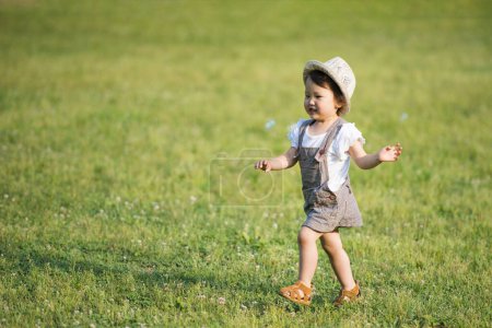 Photo for Cute asian little girl running in the field - Royalty Free Image