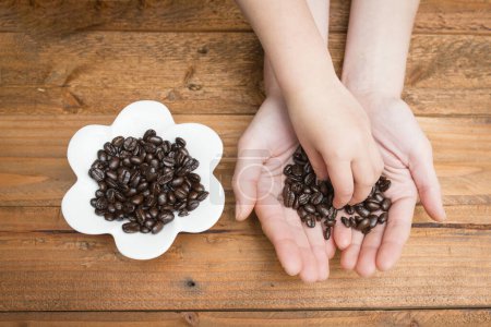 Parent and child hand with coffee beans