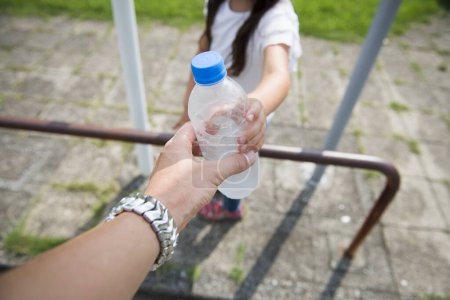 Foto de Botella de agua para manos de padres e hijos - Imagen libre de derechos