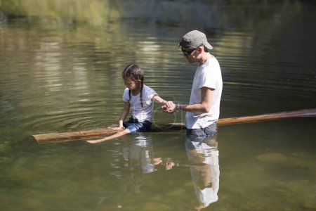 Photo for Father and daughter playing in the river - Royalty Free Image