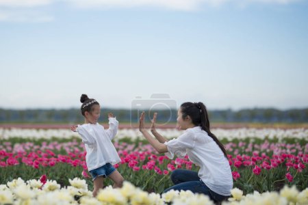 Foto de Feliz niña jugando en un campo de tulipanes - Imagen libre de derechos