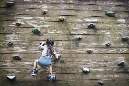 Foto de Niña escalando la pared - Imagen libre de derechos