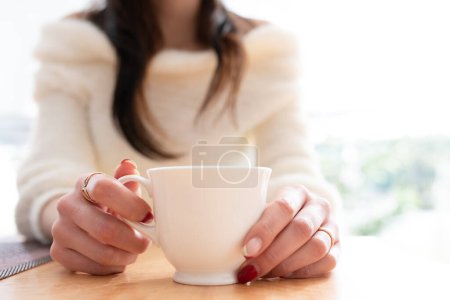 Photo for Hands of a woman drinking coffee - Royalty Free Image