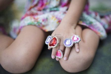 Téléchargez les photos : Main d'enfant avec beaucoup d'anneaux de jouets - en image libre de droit