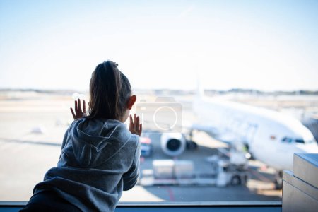 Téléchargez les photos : Mignon asiatique petite fille à la recherche sur avion dans aéroport - en image libre de droit