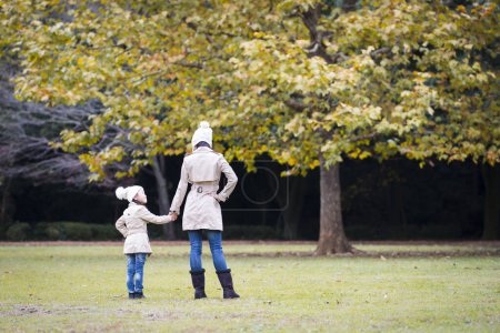 Téléchargez les photos : Mère et fille jouant dans le parc d'automne - en image libre de droit