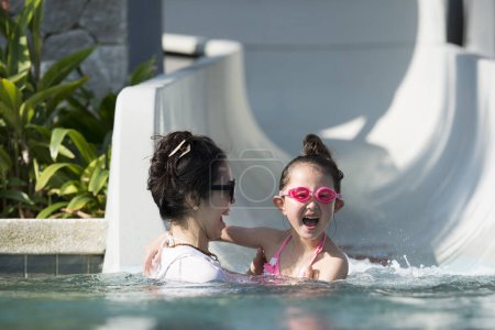 Mother and daughter playing with a water slider