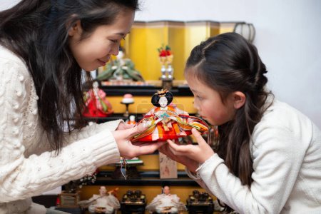 Mother and daughter decorating dolls
