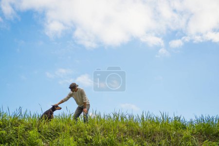 Foto de Hombre jugando con perro en el césped - Imagen libre de derechos