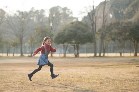 Téléchargez les photos : Jeune fille asiatique courir dans le parc - en image libre de droit