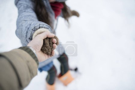Téléchargez les photos : Père et fille se tenant la main sur la route de neige - en image libre de droit