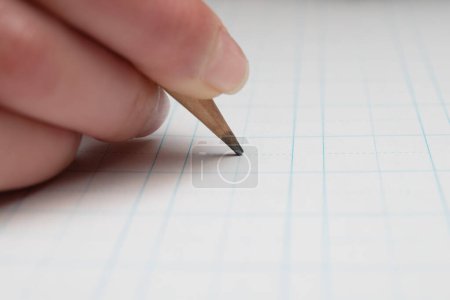 Téléchargez les photos : Un enfant qui écrit avec un crayon - en image libre de droit