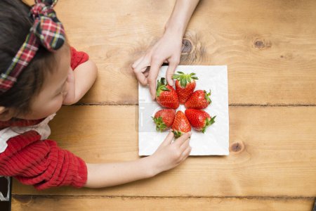 Photo for Strawberries on plate and Little Girl - Royalty Free Image