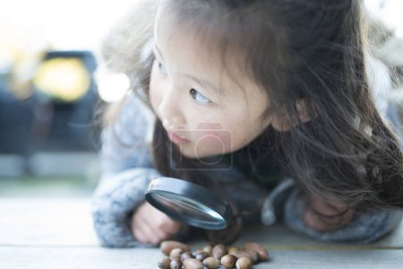 Photo for Little girl playing with magnifying glass - Royalty Free Image