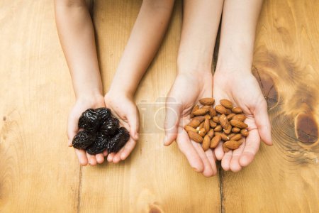 Photo for Child with prunes and mother with almonds - Royalty Free Image