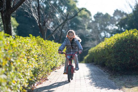 Photo for Happy child on bicycle  on the road in autumn park - Royalty Free Image