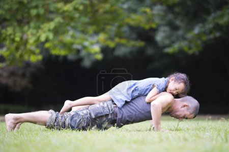 Téléchargez les photos : Père et fille se détendre sur la pelouse - en image libre de droit