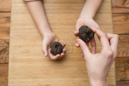 Photo for Parent and child hands handing truffles - Royalty Free Image