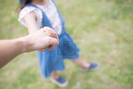 Téléchargez les photos : Parent et enfant se tenant la main dans le parc - en image libre de droit
