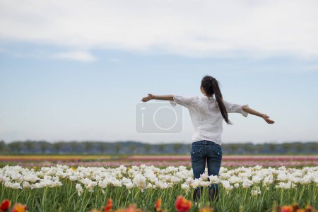 Foto de Mujer relajándose en el campo de tulipanes - Imagen libre de derechos