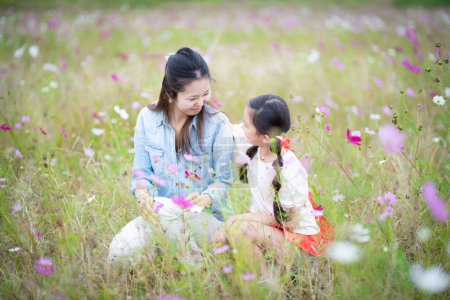 Mother and daughter playing in a flower field