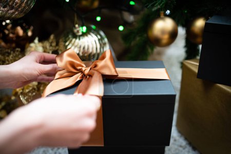 Téléchargez les photos : Main féminine tenant un cadeau de Noël - en image libre de droit