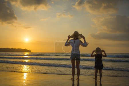 Photo for Mother and daughter playing at the sunset beach - Royalty Free Image