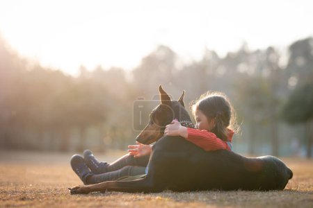 Téléchargez les photos : Petite fille jouer avec un chien - en image libre de droit