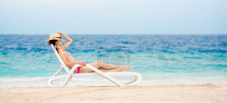 Téléchargez les photos : Belle femme relaxante sur la plage - en image libre de droit